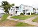 Two story condo with balconies and outdoor seating, surrounded by green lawn at 5129 Se Salmon Se Dr # A, St Petersburg, FL 33705