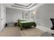 Cozy bedroom featuring a tray ceiling, carpeted floor, and natural light at 5501 N 15Th St, Tampa, FL 33610