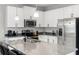 Stylish kitchen with white cabinetry, stainless steel appliances, and a granite island with bar stools at 5501 N 15Th St, Tampa, FL 33610