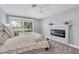 A primary bedroom features a fireplace, carpet, ceiling fan, and access to a private deck through sliding glass doors at 5559 Escondida S Blvd, St Petersburg, FL 33715
