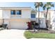 Charming townhome featuring a two-car garage, well-kept landscaping, and a classic stucco and siding exterior at 5559 Escondida S Blvd, St Petersburg, FL 33715