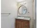 A bathroom featuring granite countertops, a round mirror, and updated lighting fixtures at 5601 16Th N St, St Petersburg, FL 33703