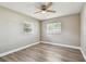 This bedroom features modern ceiling fan, two windows and beautiful, light woodgrain-look flooring at 5601 16Th N St, St Petersburg, FL 33703