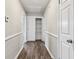 Hallway featuring wood-look flooring, neutral paint, and white trim detail, leading to bedrooms and closets at 5601 16Th N St, St Petersburg, FL 33703