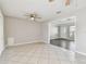 Spacious living room with tile flooring, ceiling fan, and easy access to the front door and adjacent room at 5601 16Th N St, St Petersburg, FL 33703