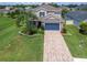 Elevated view of a charming home with a well-kept lawn, neat landscaping, and a brick-paved driveway in a lovely neighborhood at 879 De Soto Blvd, Tarpon Springs, FL 34689
