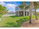 Expansive backyard with lush green lawn, covered patio area, and mature palm trees at 879 De Soto Blvd, Tarpon Springs, FL 34689