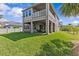 Large backyard with a well-kept lawn, spacious patio, and upper-level balcony at 879 De Soto Blvd, Tarpon Springs, FL 34689