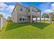 Two story home backyard featuring well-manicured lawn, a balcony and covered patio at 879 De Soto Blvd, Tarpon Springs, FL 34689