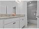 Bathroom featuring double vanity with granite countertop and walk-in shower at 879 De Soto Blvd, Tarpon Springs, FL 34689