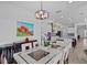 Elegant dining area with seating for eight adjoins a kitchen with white cabinets and stainless appliances at 879 De Soto Blvd, Tarpon Springs, FL 34689