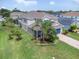 Aerial view of two-story home with well-manicured landscaping and a blue garage door at 879 De Soto Blvd, Tarpon Springs, FL 34689