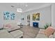 Contemporary living room with white sofas, modern artwork, tile flooring, and a stylish light fixture at 879 De Soto Blvd, Tarpon Springs, FL 34689