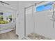 Glass shower with pebble tile floor, handheld sprayer and overhead showerhead at 879 De Soto Blvd, Tarpon Springs, FL 34689