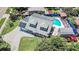 Aerial view of home showcasing solar panels, spacious lot, driveway, private pool, and outdoor entertaining area at 9201 86Th Ave, Seminole, FL 33777