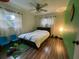 Bright bedroom features hardwood floors, a ceiling fan, and natural light through the windows at 9201 86Th Ave, Seminole, FL 33777