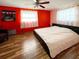 This charming bedroom features hardwood floors, a large window, and an eye-catching red accent wall at 9201 86Th Ave, Seminole, FL 33777