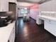Modern kitchen and dining area featuring stainless steel appliances, white cabinetry, and dark wood flooring at 9201 86Th Ave, Seminole, FL 33777