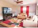 Cozy living room with hardwood floors, TV, fireplace, ceiling fan, and comfortable seating at 9201 86Th Ave, Seminole, FL 33777