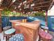 The outdoor bar features custom stools, a countertop, and a roof decorated with license plates at 9201 86Th Ave, Seminole, FL 33777