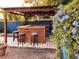 Charming outdoor bar area with wooden structure, stools, and vibrant climbing flowers at 9201 86Th Ave, Seminole, FL 33777