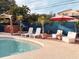 Inviting backyard pool area featuring a tiki bar, lounge chairs, and lush tropical landscaping at 9201 86Th Ave, Seminole, FL 33777