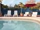 Relaxing pool area with lounge chairs, umbrella, and lush landscaping for a perfect outdoor retreat at 9201 86Th Ave, Seminole, FL 33777