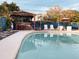 Serene backyard pool with tiki bar, lush greenery, and comfortable lounge seating at 9201 86Th Ave, Seminole, FL 33777