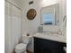 Bright bathroom with a shower, white tiled walls, a modern toilet, and a vanity with storage space at 9298 Carr Rd, Riverview, FL 33569