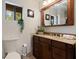 Bathroom featuring marble countertops, dark wood cabinets, decorative mirror, and view of natural scenery at 9298 Carr Rd, Riverview, FL 33569