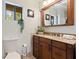 Bright bathroom features a stylish vanity with granite countertop, wood cabinets, and a framed mirror at 9298 Carr Rd, Riverview, FL 33569