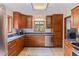 Well-lit kitchen with stainless steel appliances, wood cabinets, granite countertops, and a view to the backyard at 9298 Carr Rd, Riverview, FL 33569