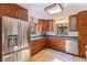 Bright kitchen featuring stainless steel appliances, granite countertops, wood cabinetry, and a view from the window at 9298 Carr Rd, Riverview, FL 33569