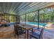 Enclosed patio with dining area, lounge furniture, and a view of the sparkling pool and lush outdoor space at 9298 Carr Rd, Riverview, FL 33569