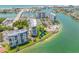 Gorgeous aerial view of waterfront condos with a marina, pool, and stunning lake views at 9495 Blind Pass Rd # 406, St Pete Beach, FL 33706