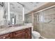 Bathroom featuring updated vanity with granite countertops, stylish fixtures and a modern glass-enclosed shower at 9495 Blind Pass Rd # 406, St Pete Beach, FL 33706