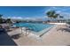 Beautiful community pool with plenty of lounge chairs and clear blue water on a sunny day with palm trees in the background at 9495 Blind Pass Rd # 406, St Pete Beach, FL 33706