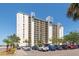 Exterior view of a luxurious waterfront condominium featuring multiple balconies and parking at 9495 Blind Pass Rd # 406, St Pete Beach, FL 33706