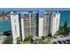 Exterior view of a luxurious waterfront condominium featuring multiple balconies and parking at 9495 Blind Pass Rd # 406, St Pete Beach, FL 33706