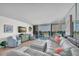 Bright living room with comfortable seating, stylish decor, and serene water views beyond the balcony at 9495 Blind Pass Rd # 406, St Pete Beach, FL 33706