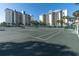 Exterior view of a tennis court available to the residents of the condo buildings in the background on a sunny day at 9495 Blind Pass Rd # 406, St Pete Beach, FL 33706