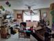 Multi-purpose living room with tile floors, a ceiling fan, a desk, and a large window providing natural light at 1155 Royalwood Dr, Holiday, FL 34690