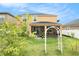 Exterior view of the home featuring a large backyard and covered patio at 11818 Valhalla Woods Dr, Riverview, FL 33579