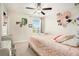 Comfortable bedroom with a bright window, mirrored dresser, ceiling fan, and plush carpet floors at 11818 Valhalla Woods Dr, Riverview, FL 33579