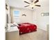 Bright bedroom features a ceiling fan and a comfortable red covered bed at 11818 Valhalla Woods Dr, Riverview, FL 33579