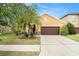 Charming single-Gathering home featuring a well-manicured lawn and a two-car garage with a lovely palm tree at 11818 Valhalla Woods Dr, Riverview, FL 33579