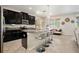 Modern kitchen features dark cabinets, granite countertops, and a central island with seating at 11818 Valhalla Woods Dr, Riverview, FL 33579