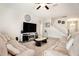Spacious living room featuring a large television, comfortable seating, and a staircase leading to the upper level at 11818 Valhalla Woods Dr, Riverview, FL 33579