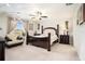Elegant main bedroom featuring a king bed, dark wood furniture, and ample natural light at 11818 Valhalla Woods Dr, Riverview, FL 33579