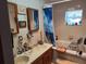 Bathroom featuring a double sink vanity, tub, window with lace curtains and walk-in shower at 12231 Fort King Rd, Dade City, FL 33525